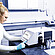 A technician operates an Anton Paar DMA 4501 density meter in a lab, with sample vials and printed documentation on the workbench.