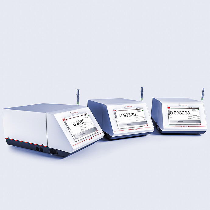 Anton Paar DMA 4101, DMA 4501, and DMA 5001 density meters side by side, each equipped with a syringe and showing digital measurement values.